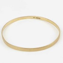 A 9ct gold bangle with engine turned decoration, internal diameter approx. 7.8cm, approx. 14.8g.