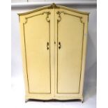 A five-piece gilt-heightened cream bedroom suite comprising two double wardrobes, a chest of five