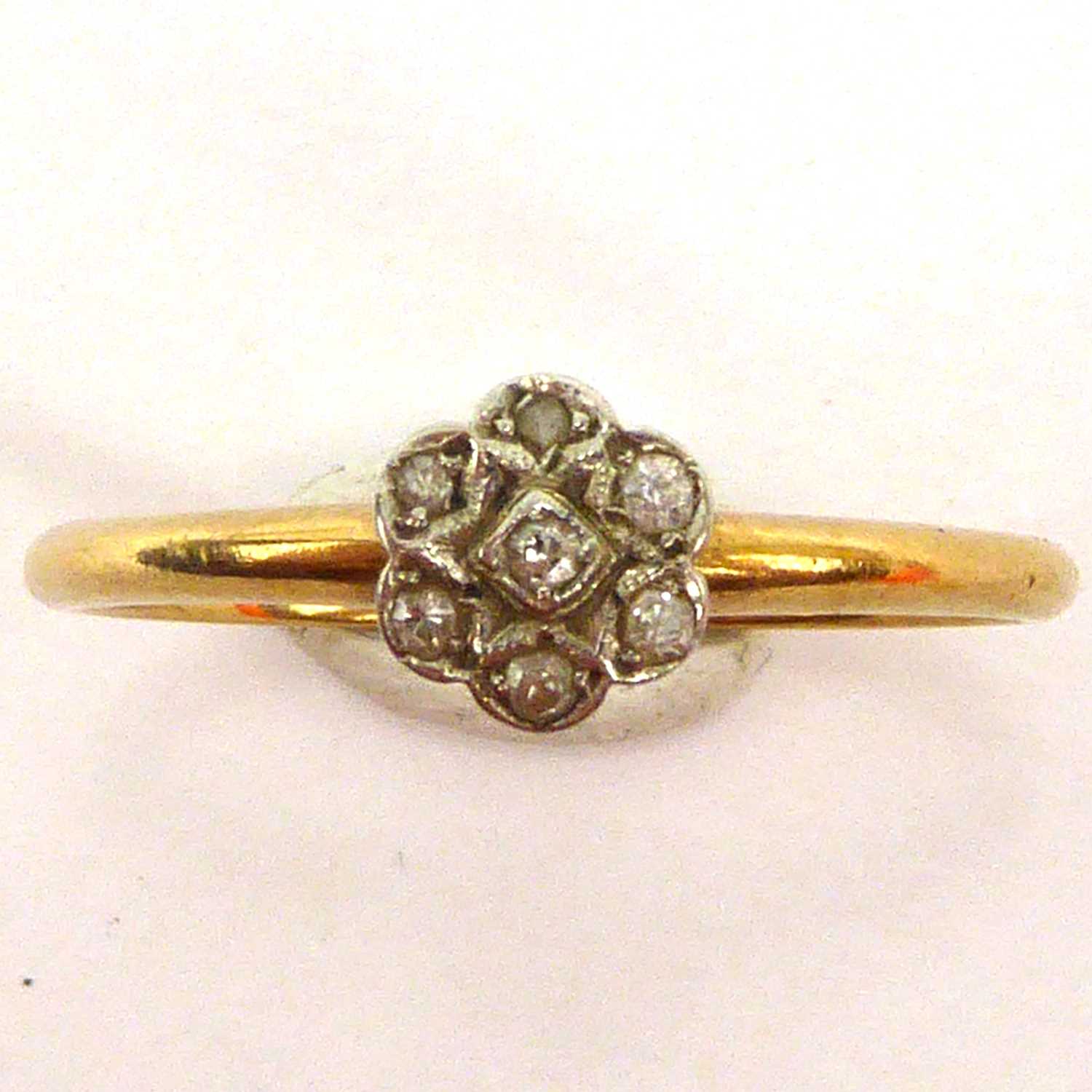 An 18ct gold ring with small diamond floral cluster, size P, approx. 2g.