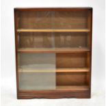 A mid-20th century dark oak bookcase with tin sliding glass doors and three interior shelves, to