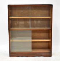 A mid-20th century dark oak bookcase with tin sliding glass doors and three interior shelves, to