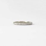 A white metal and diamond full eternity ring, size T, approx. 3.1g (one stone missing).