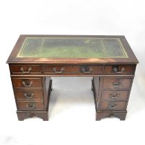 A modern reproduction pedestal desk, the inset green leather top over three small drawers, on two