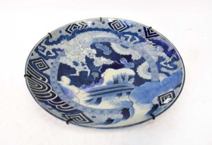 A 19th century Japanese blue and white charger with geometric patterns around a central vignette