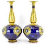 ROYAL DOULTON, LAMBETH; a pair of art pottery vases of globe and tapered shaft form, with flared