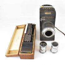 An early 20th century tinplate electric magic lantern and two additional lenses, together with a