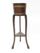 An early 20th century torchère stand in the form of an oak coopered barrel, with applied internal