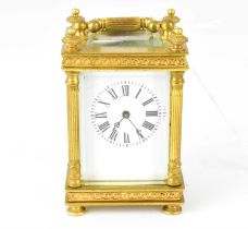 A small brass cased miniature carriage clock, the white enamelled dial set with Roman numerals,
