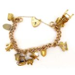 A 9ct gold charm bracelet with nine gold charms to include oxen and sled, chair and guitar, shields,