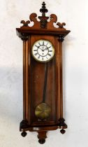 An early 20th century walnut cased single-weight Vienna wall clock, the white enamelled dial set