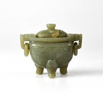 A Chinese jade twin-handled lidded vessel, the ring handles held in the mouths of beasts, the body