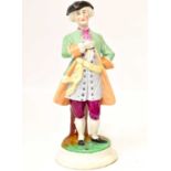 A 19th century tall Staffordshire pottery figure of a dandy man, with tricorne hat, green coat and