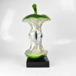 A contemporary resin sculpture of an apple core, on black square section base, height 55cm.