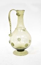 A 19th century pale green glass jug with raised roundels to stepped circular base, height 26.5cm (