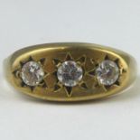 A 9ct gold ring with three white stones in a star inset mount, on an oval table, size T, approx.