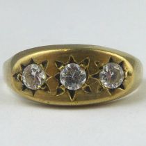 A 9ct gold ring with three white stones in a star inset mount, on an oval table, size T, approx.