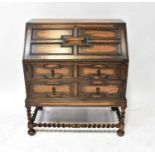 An early 20th century oak bureau, the fall front enclosing a basic fitted interior, above a base