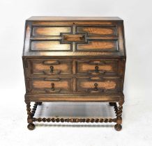 An early 20th century oak bureau, the fall front enclosing a basic fitted interior, above a base