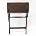 An early 20th century mahogany folding writing table, with fitted leather interior, on folding X-