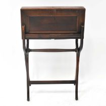 An early 20th century mahogany folding writing table, with fitted leather interior, on folding X-