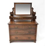 A stained oak dressing chest with bevelled mirror plate above a pair of jewellery drawers and open