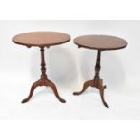 Two mahogany circular tilt-top occasional tables raised on turned columns and outswept scrolling