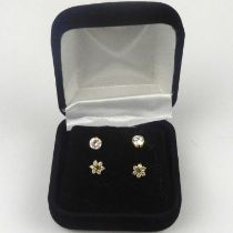 Two pairs of 9ct gold stud earrings, comprising a set of tiny flower head diamond cluster and a pair