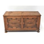 A 19th century oak coffer with applied decoration to the front, raised on bun supports, 64 x 121 x
