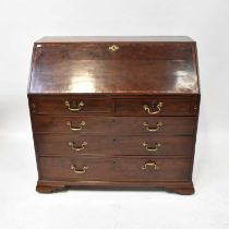 A George III mahogany bureau with marquetry inlaid fitted interior above two short and three long