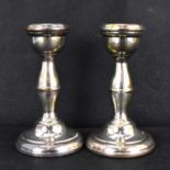 A pair of Elizabeth II hallmarked silver short candlesticks, with loaded bases, height 10cm, AT