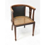 An Edwardian walnut satinwood line inlaid bergère tub chair, with studded leatherette back panel,