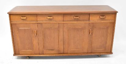 A mid-20th century oak sideboard, comprising four short drawers over two pairs of cupboard doors,