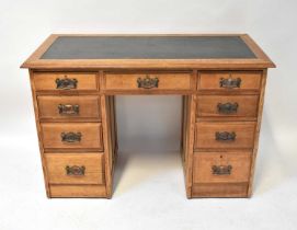 An Edwardian oak nine-drawer kneehole desk, with leather inset panel to the top, raised on plinth