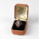 A 9ct rose gold cameo ring, the lozenge-shaped cameo depicting lady in robes, within a scrolling