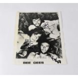 THE BEE GEES; a black and white promotional photograph signed by members of the group, Robin Gibb,
