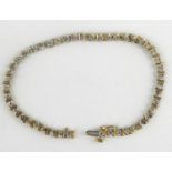 A 9ct gold diamond tennis bracelet with forty-five illusion set diamonds, separated with gold
