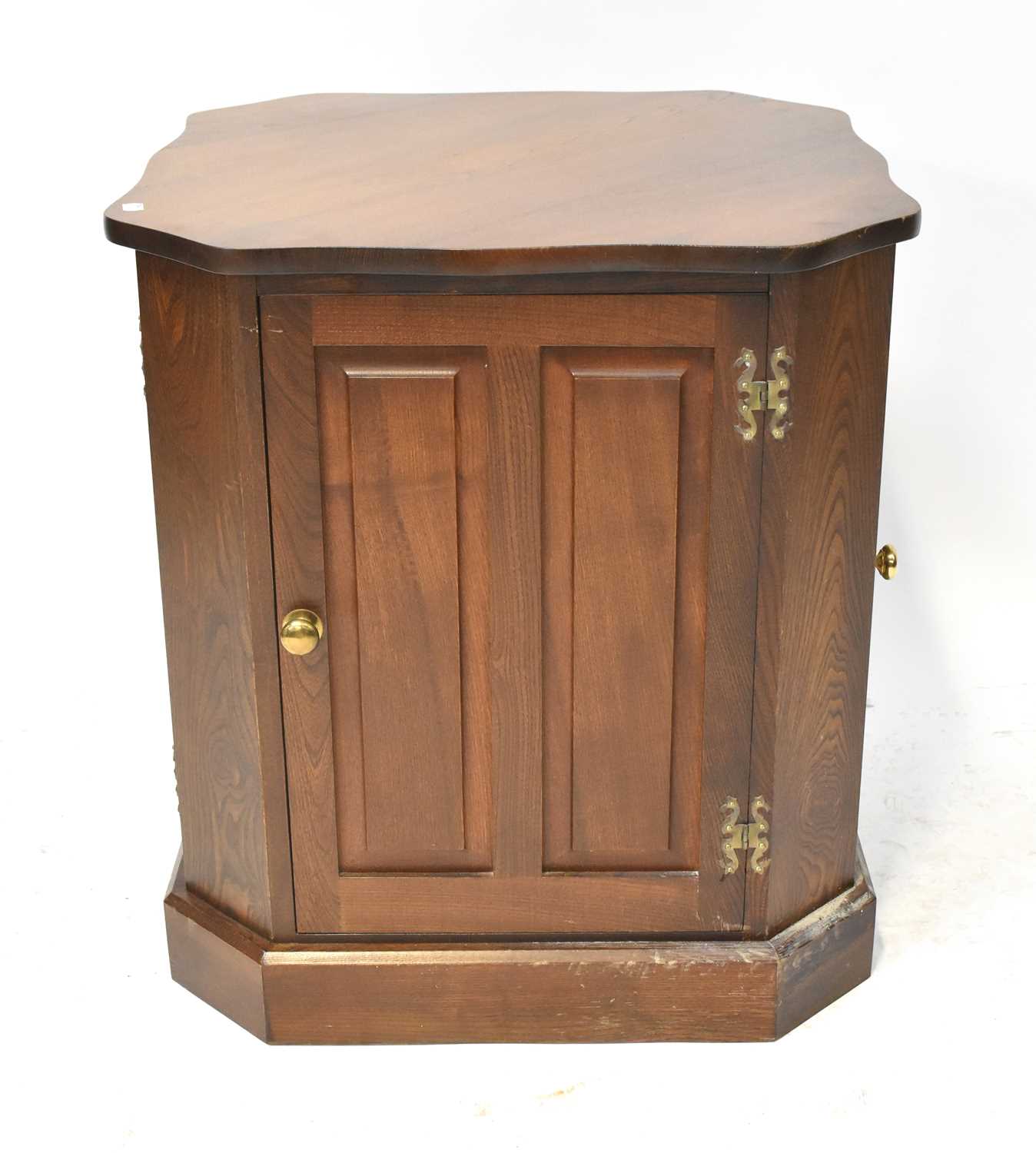 A contemporary oak freestanding cabinet, with shaped top above four panelled doors, raised on plinth