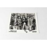TOM PETTY & THE HEARTBREAKERS; a black and white photograph signed by the band to include Tom Petty,
