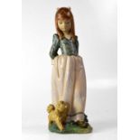 LLADRÓ; a matte glazed figure of a young lady with a dog by her feet, height 35.5cm.