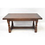 A 20th century oak refectory-style draw-leaf table, on baluster supports united by an H-stretcher,