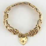 A 9ct gold three bar gate bracelet with a 9ct gold heart-shaped padlock clasp, length 19cm,