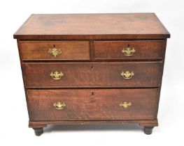 A Georgian oak and mahogany cross-banded chest of two short over two long graduated drawers,