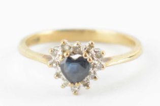 A 9ct gold ring with central heart-shaped sapphire in a heart-shaped border cluster of tiny