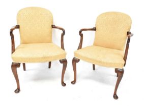 A pair of Georgian-style mahogany open elbow chairs with spoon backs and cabriole legs,