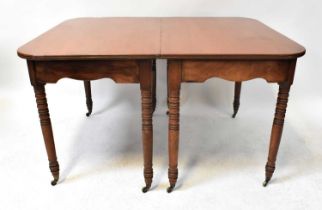 A George III mahogany extending dining table comprising a pair of D-ends, a centre drop-leaf table