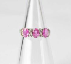 A 14ct white gold ring set with three pink sapphires interspersed with pairs of small diamonds in