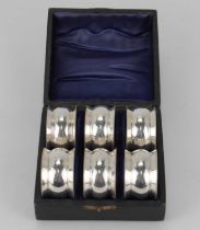 A cased set of six silver plated napkin rings of bow profile with beaded edge, diameter 4.2cm, in