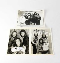 BEE GEES; two black and white promotional photographs signed by the members of the band, Robin Gibb,