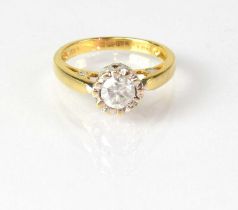 An 18ct yellow gold solitaire diamond ring, the stone in an unusual setting, inset with smaller