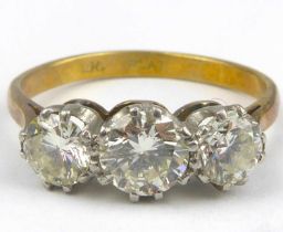 An 18ct gold three-stone diamond ring, the three claw set brilliant cut stones comprising a